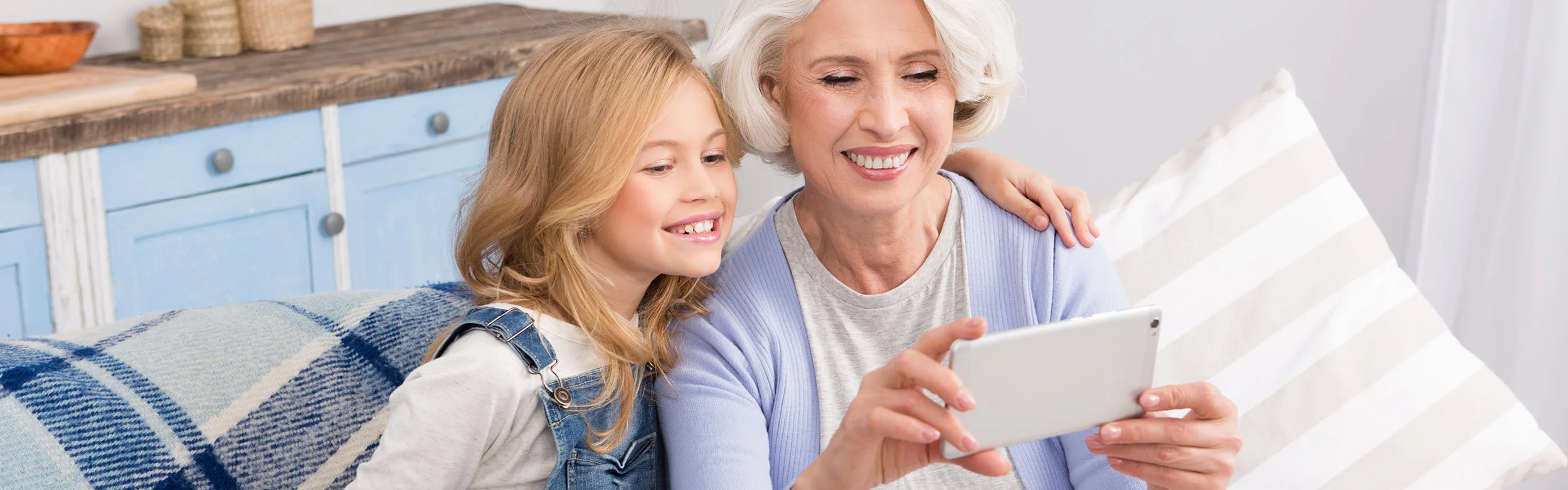 Biztonságos internet illusztrációs kép: nagymama unokával mobilinterneteznek