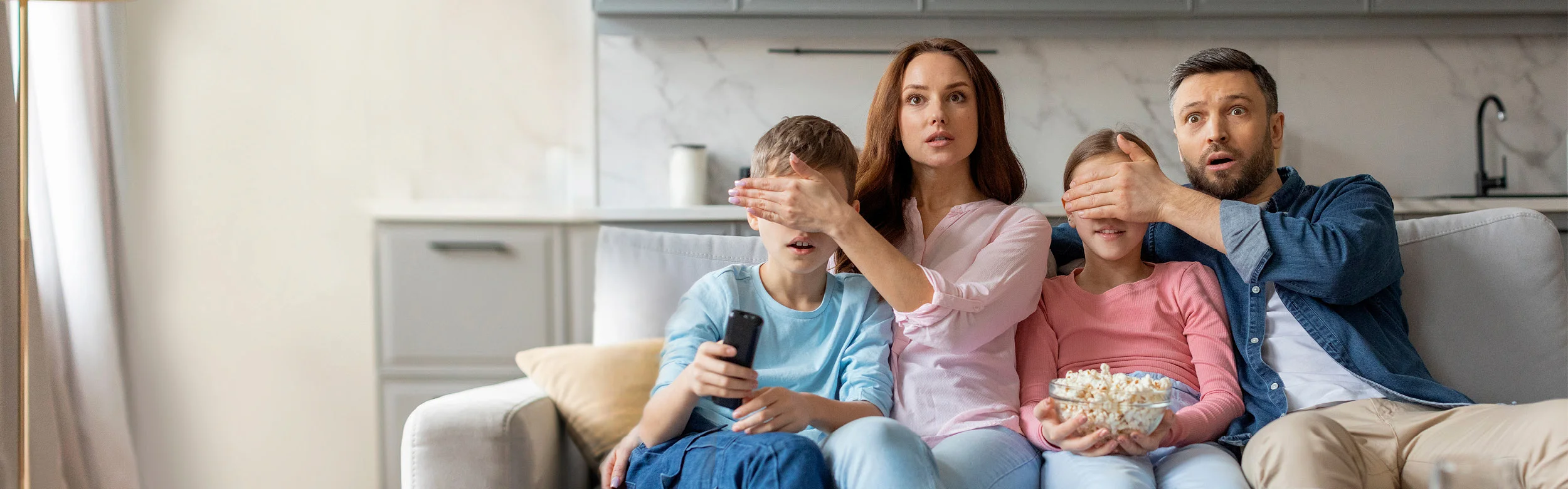 Biztonságos tv illusztrációs kép: gyerekek szüleikkel tévét néznek